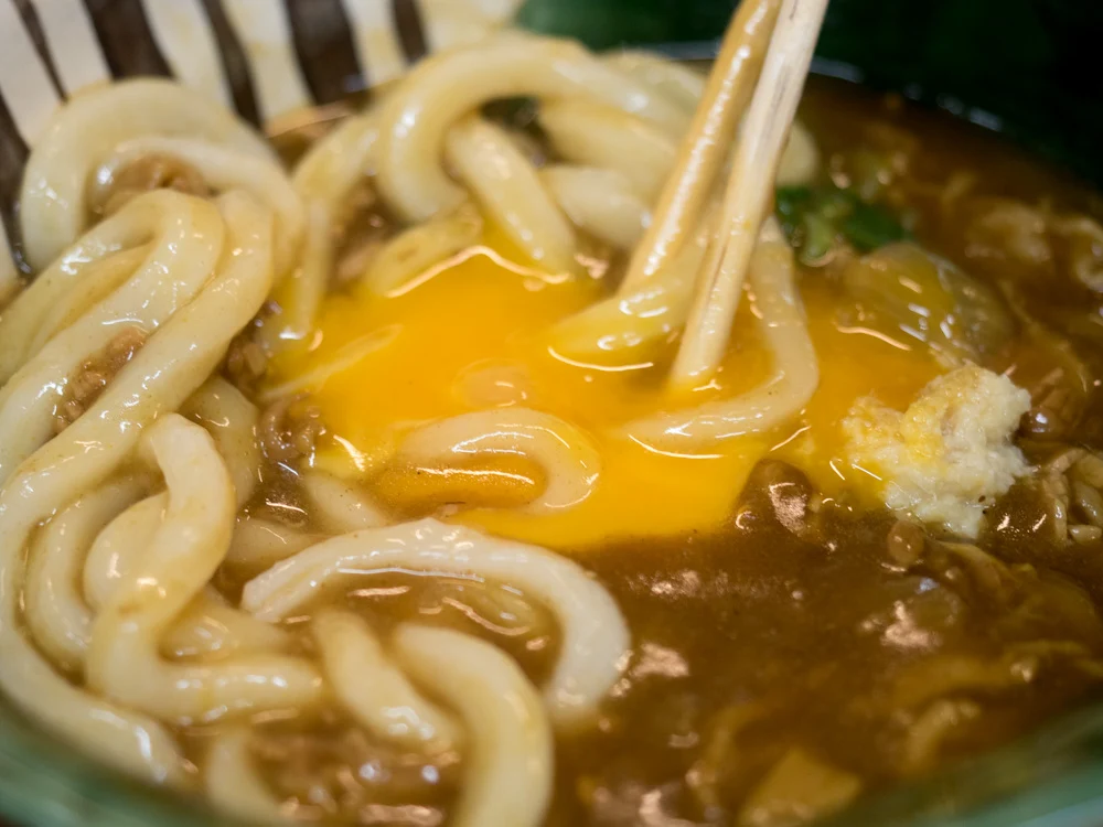 ふじ心:牛玉カレーうどんの玉子を混ぜるところ