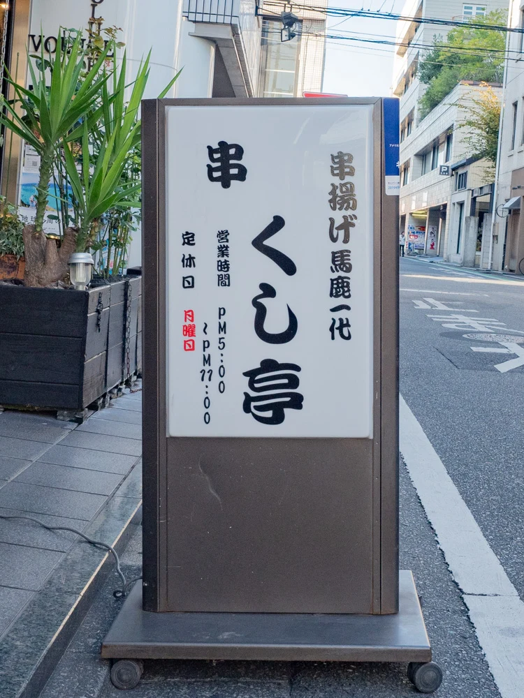 くし亭への行き方：くし亭が入居するホワイトプラザ前のくし亭看板