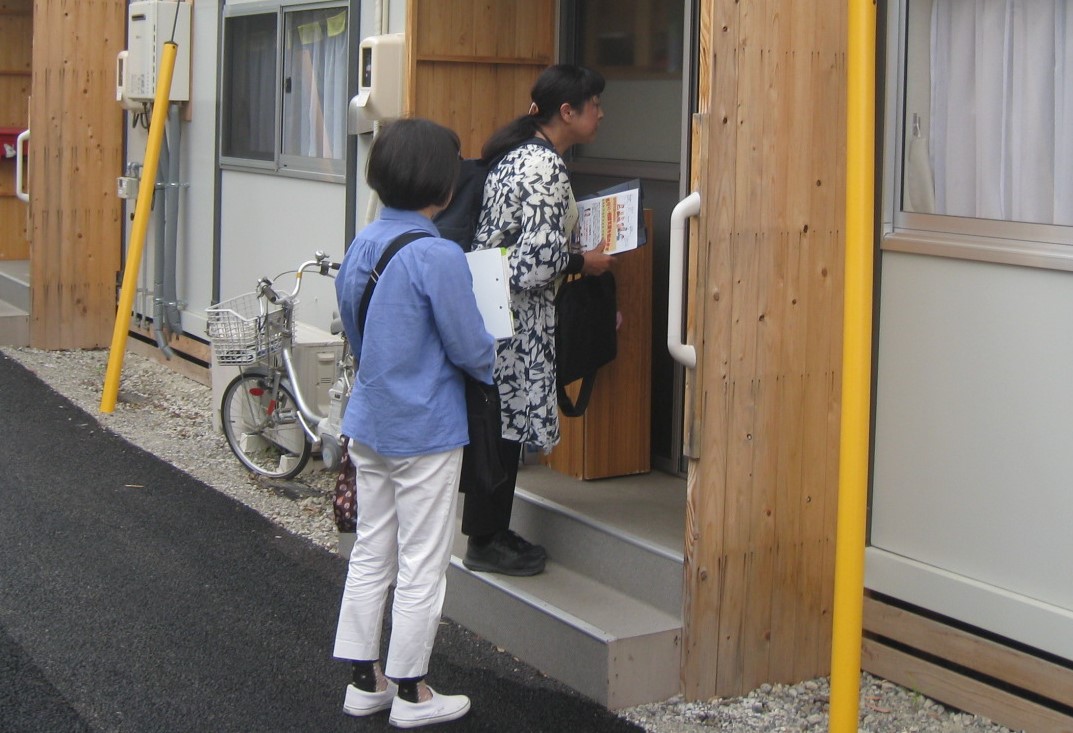 見守り連絡員が仮設住宅を訪問しているようす（写真提供：倉敷市真備支え合いセンター）