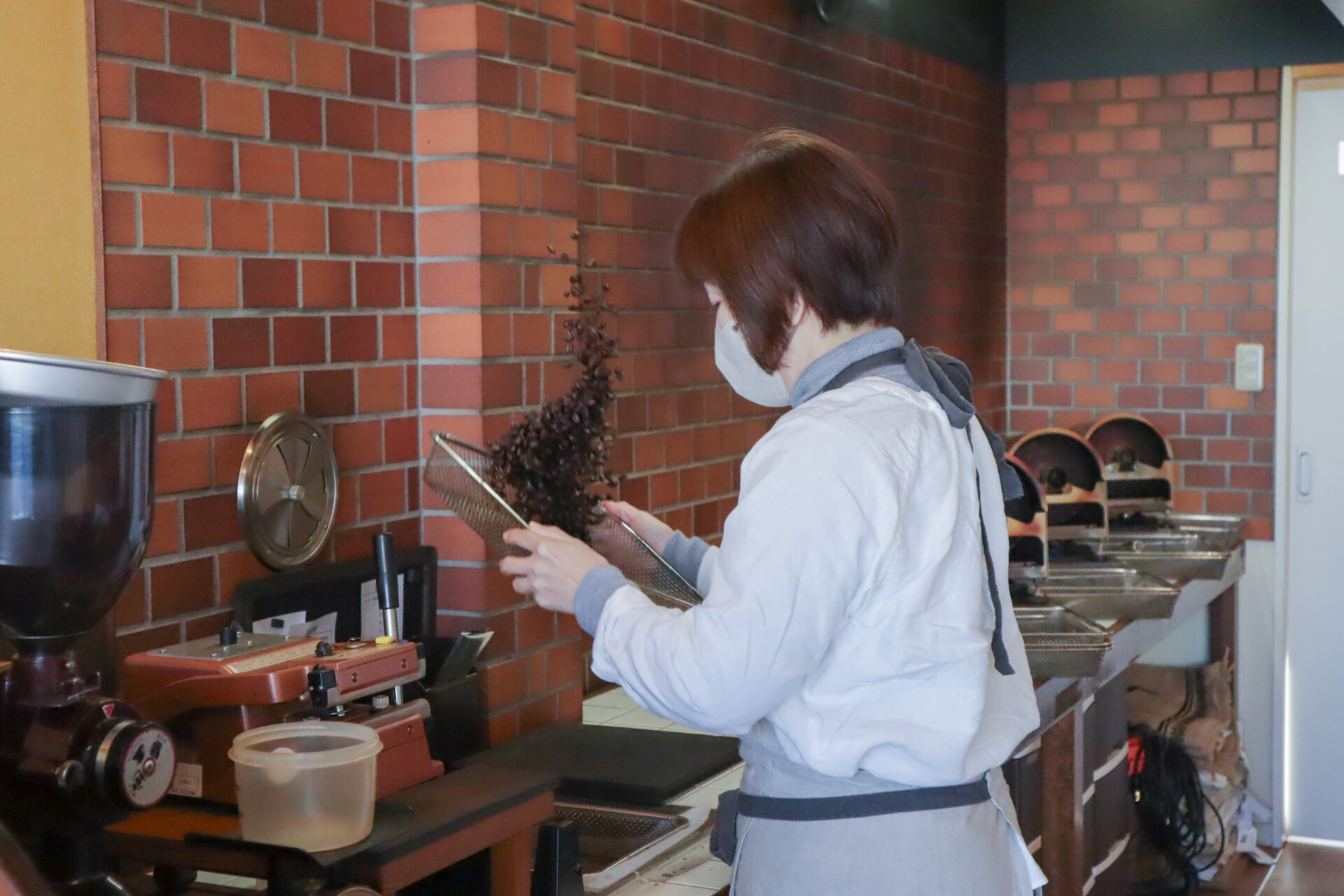 焙煎が終わったばかりの熱い豆を冷まし、豆の薄皮を除く工程