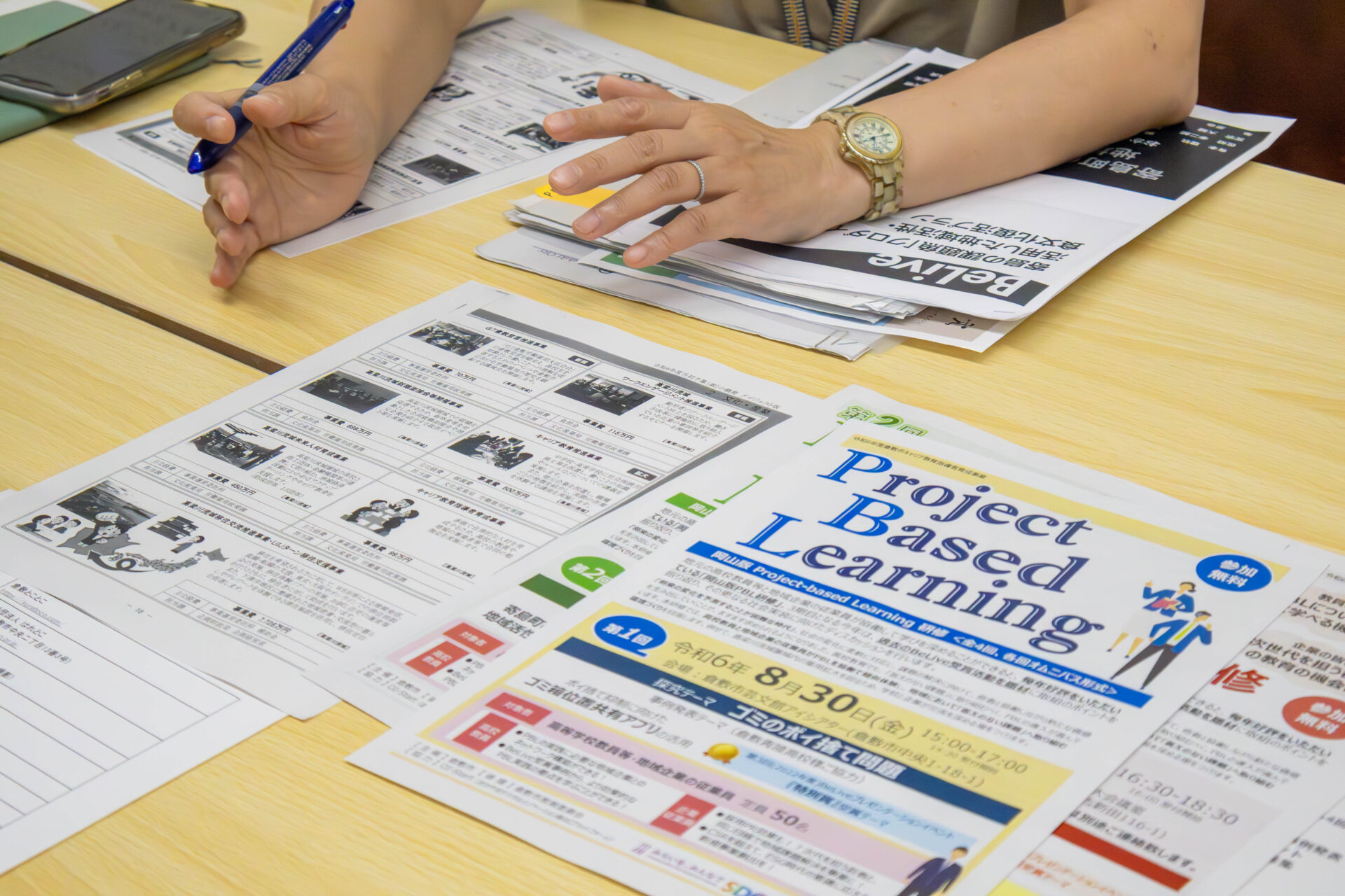 机の上に並べられたPBL研修に関する資料