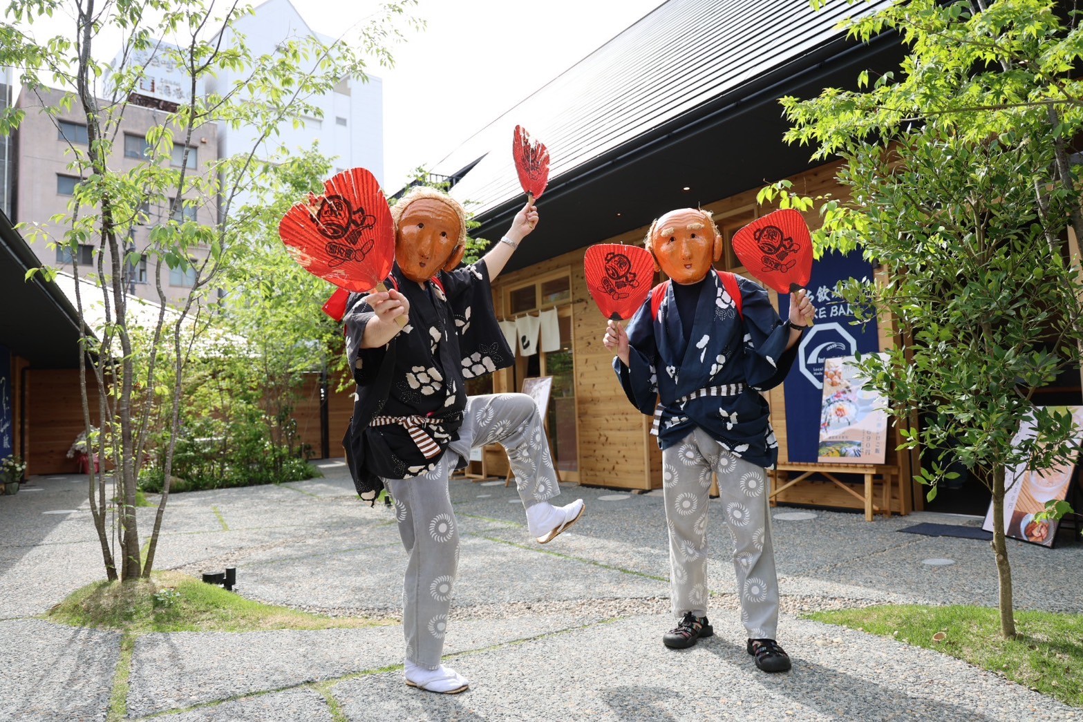 赤いうちわを持つ素隠居　画像提供：観光客の頭をうちわで叩く素隠居　画像提供：TAKAHASHIGAWA TRAVEL