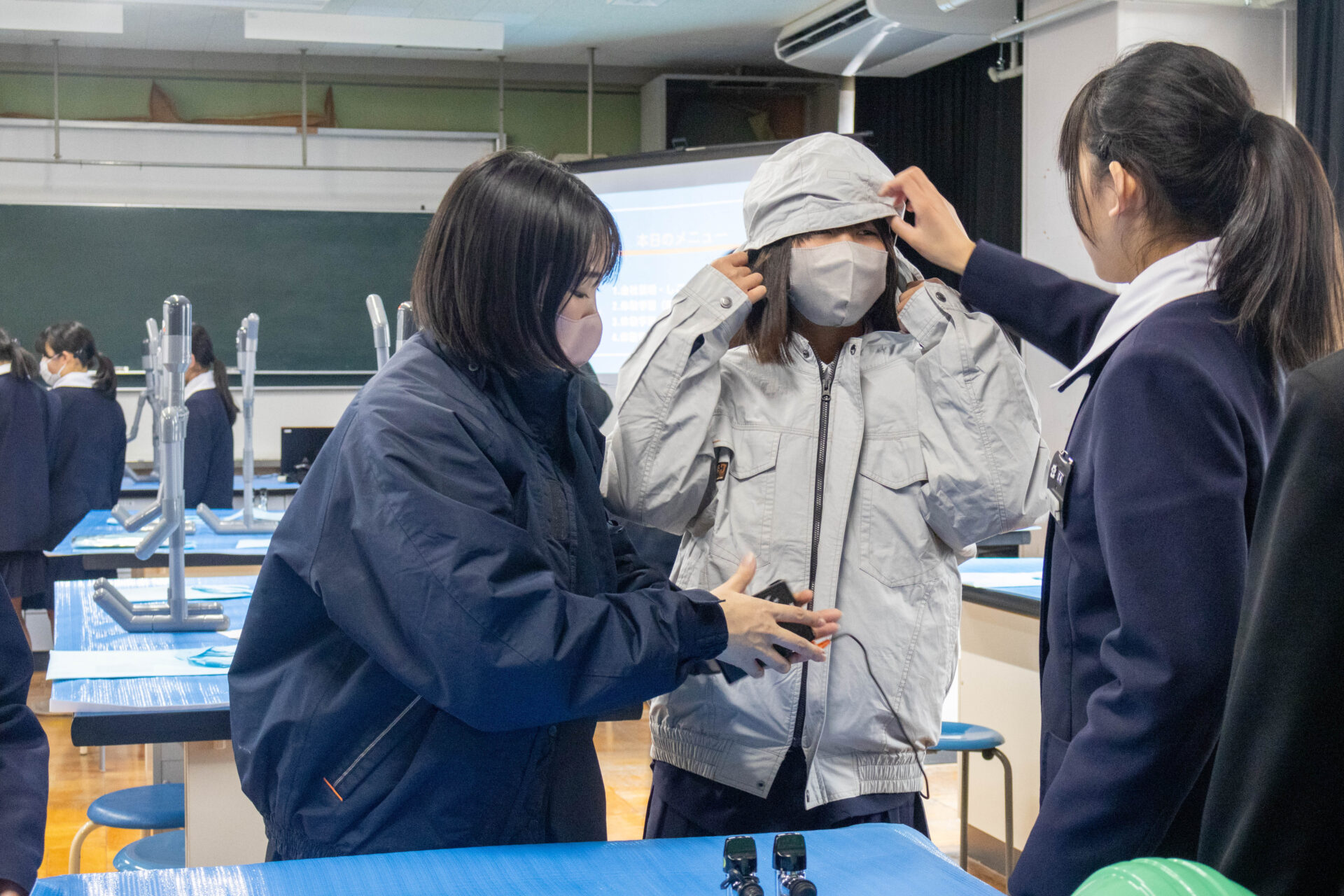 作業服やハーネスを試着する生徒