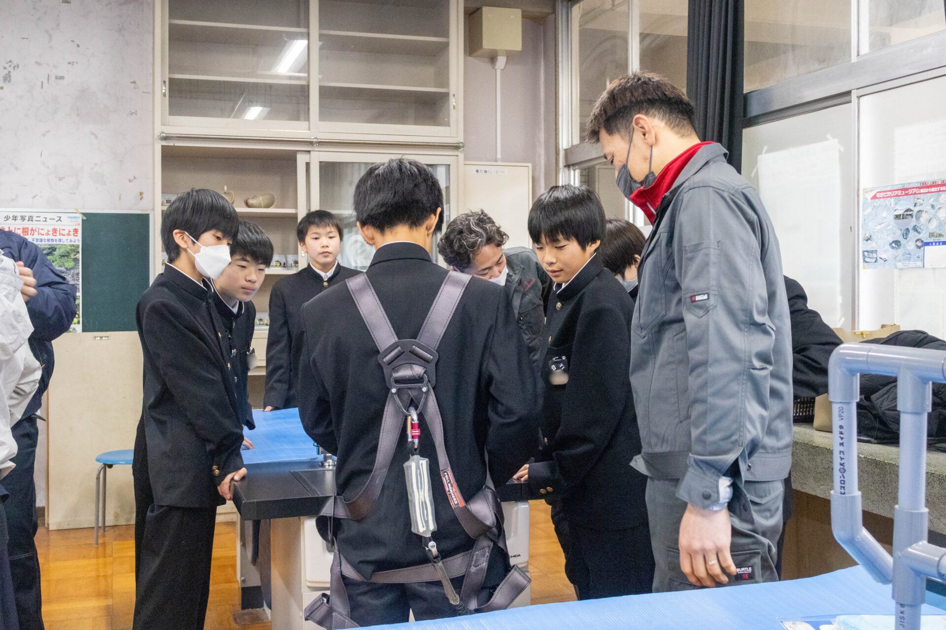作業服やハーネスを試着する生徒