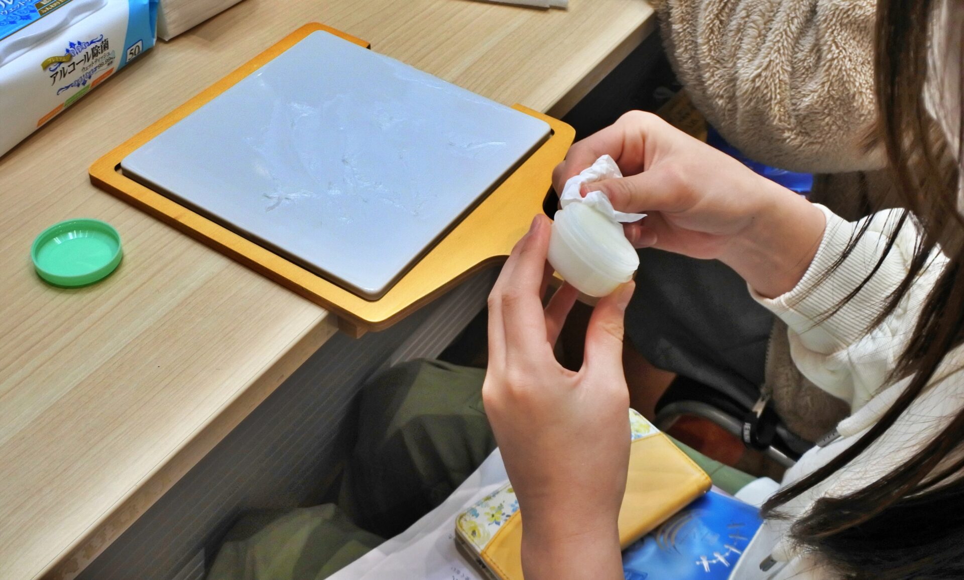 小さい容器のまわりをきれいに拭く様子