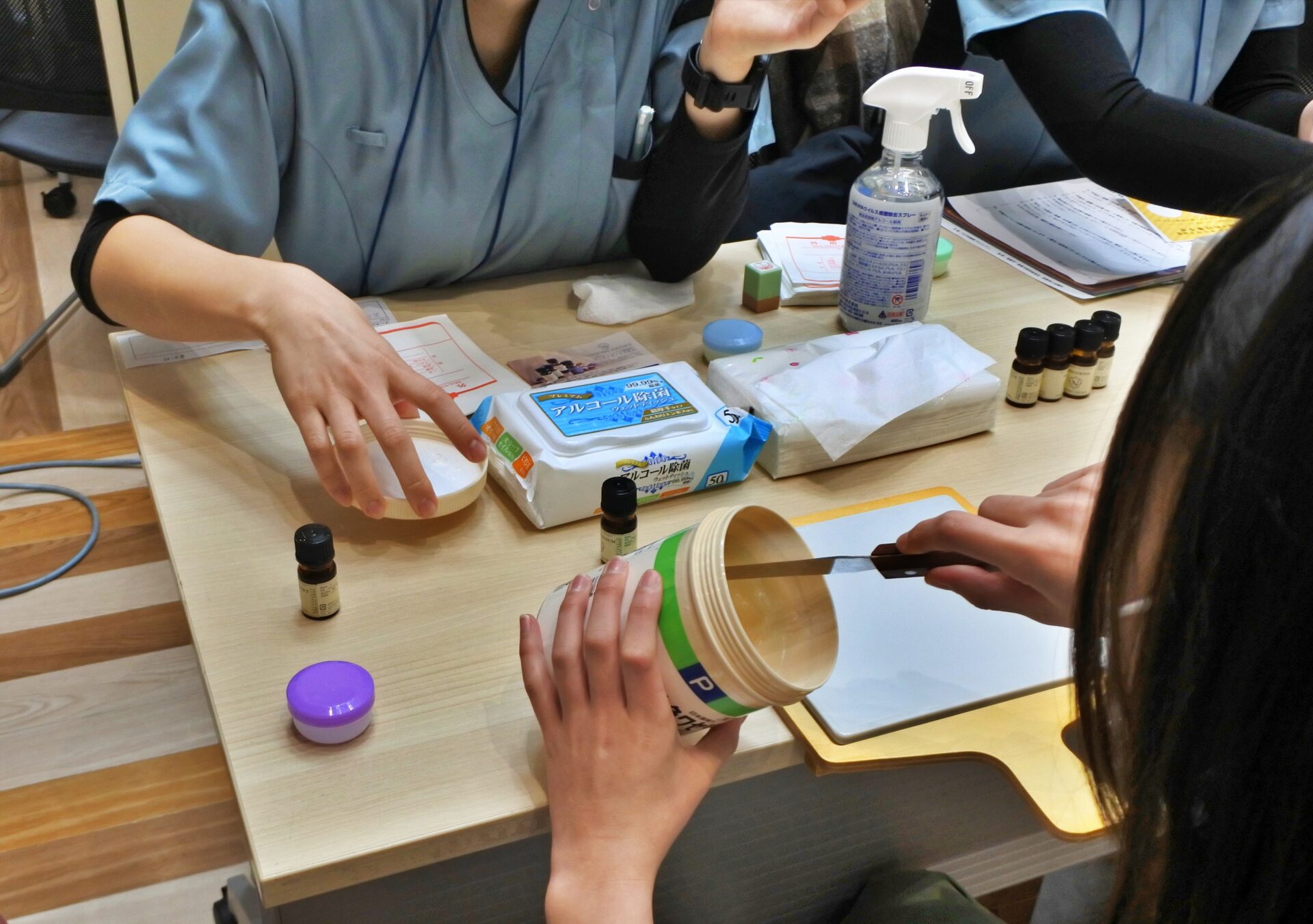 軟膏を大きな容器からヘラで取る様子