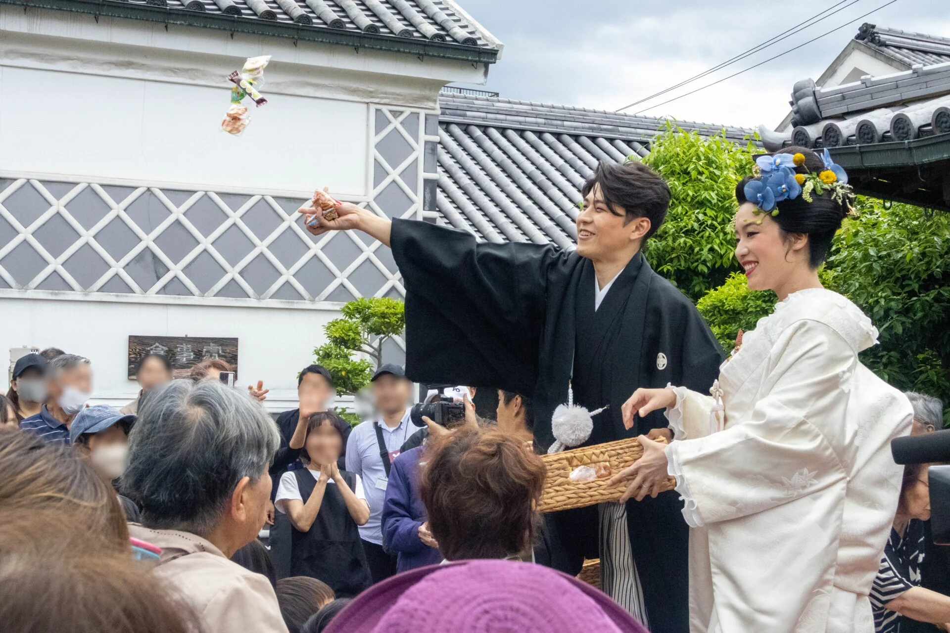 お菓子や餅をばらまく夫婦