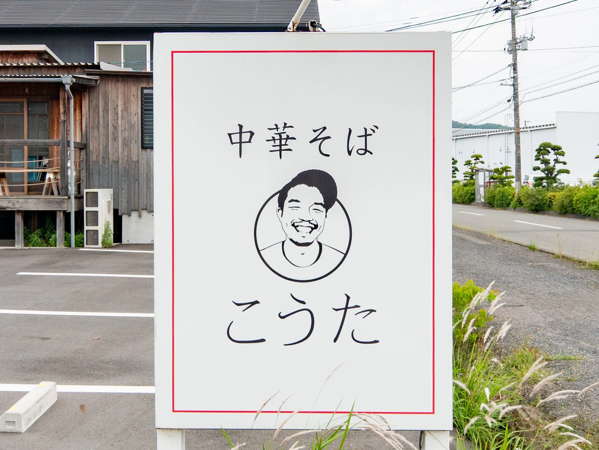 店名は代表の名前から。代表の似顔絵が描かれた看板が目印だ