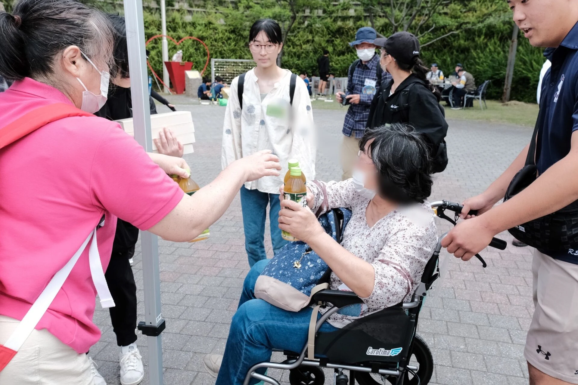 尾道市社会福祉協議会スタッフからお弁当を受け取る参加者