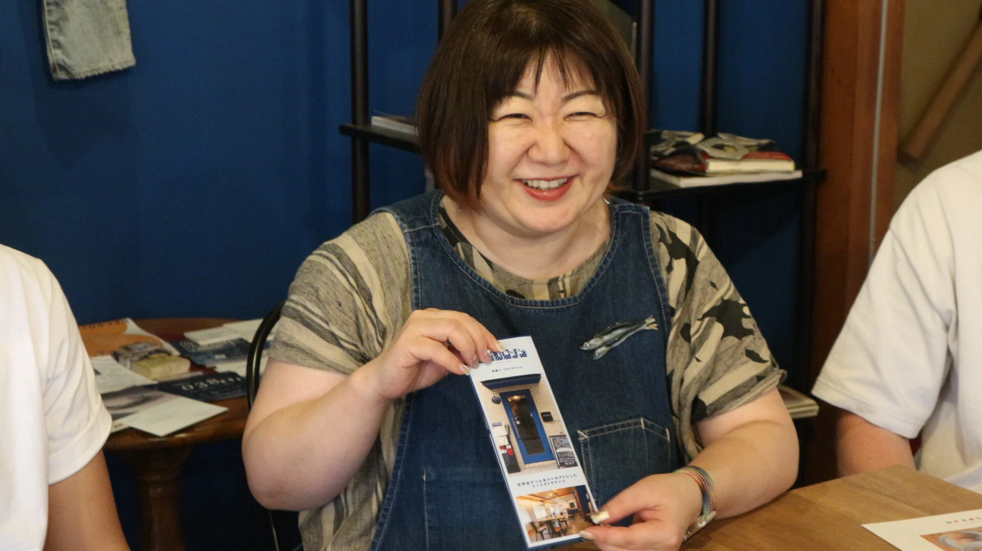 デニムロッジ・ネストのパンフレットを見せる中庭さん
