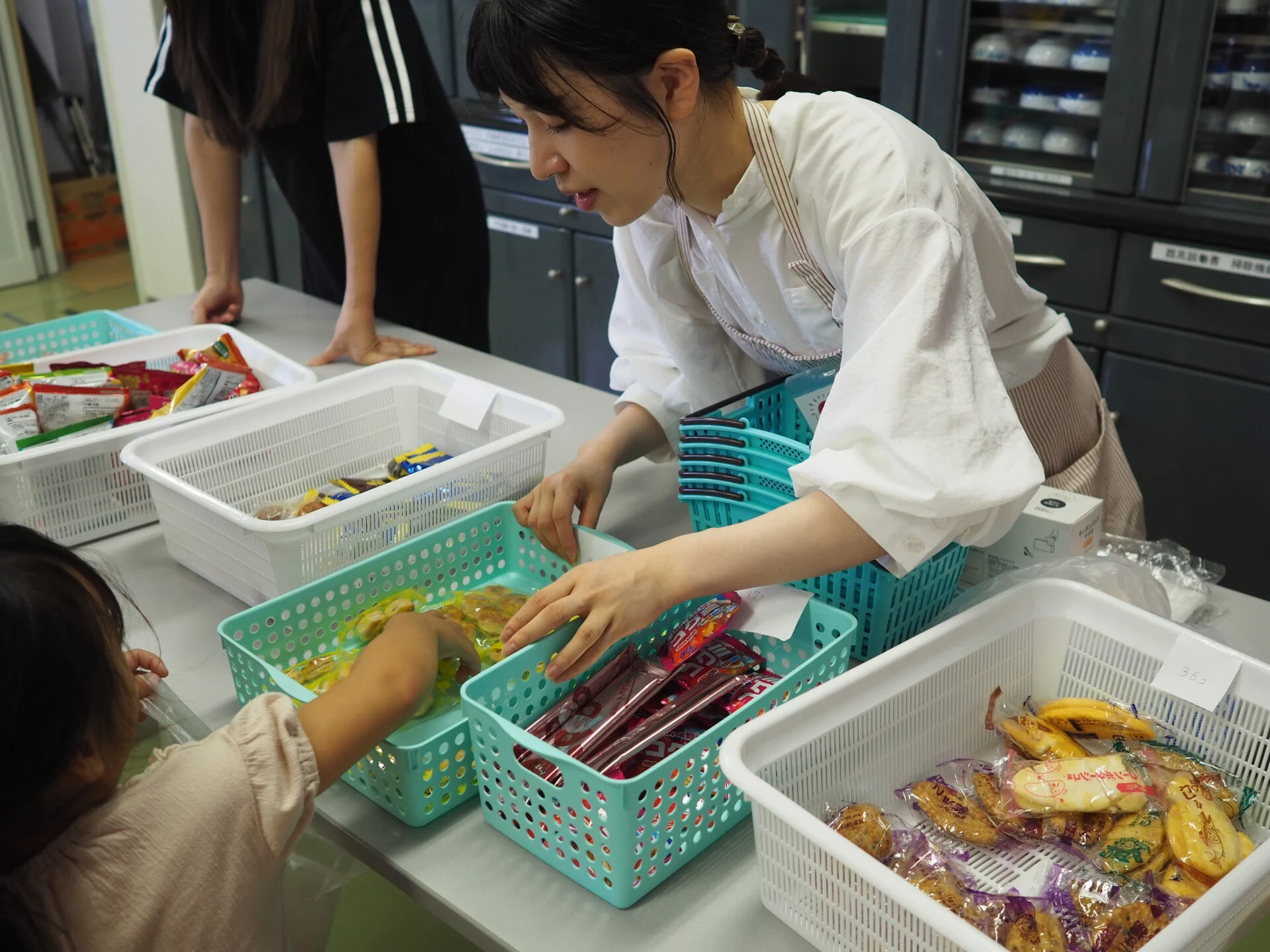お菓子を配るスタッフのりなさん