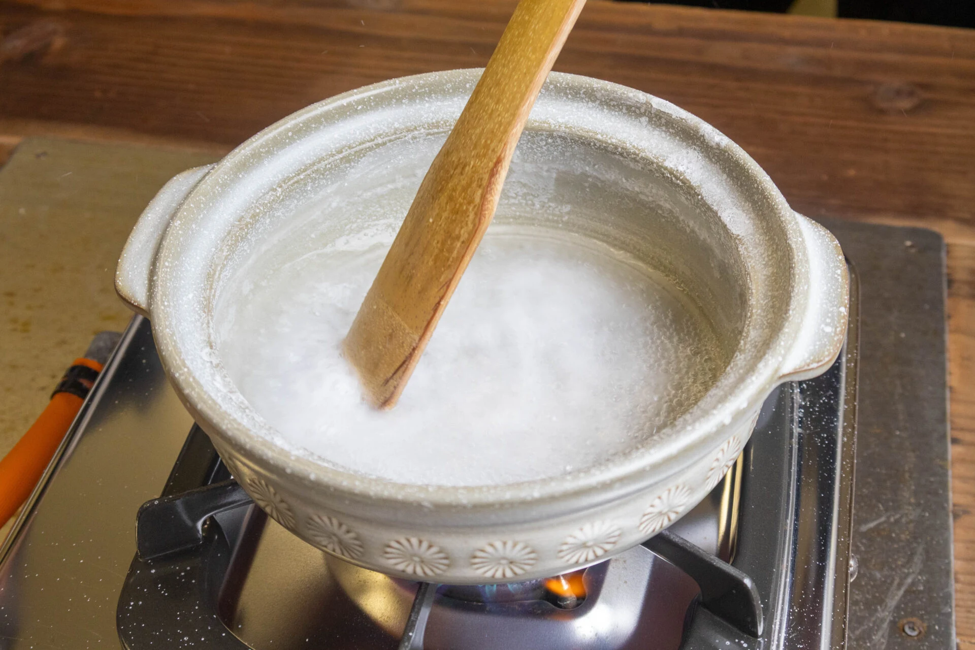 沸騰したかん水をかき混ぜている