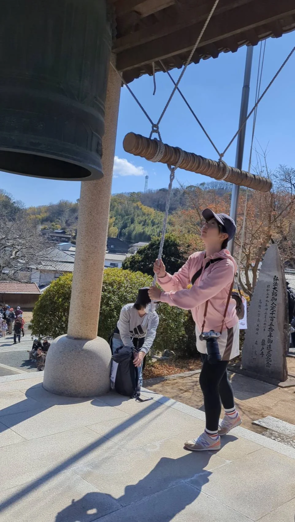 鐘をつく筆者(高石真梨子)