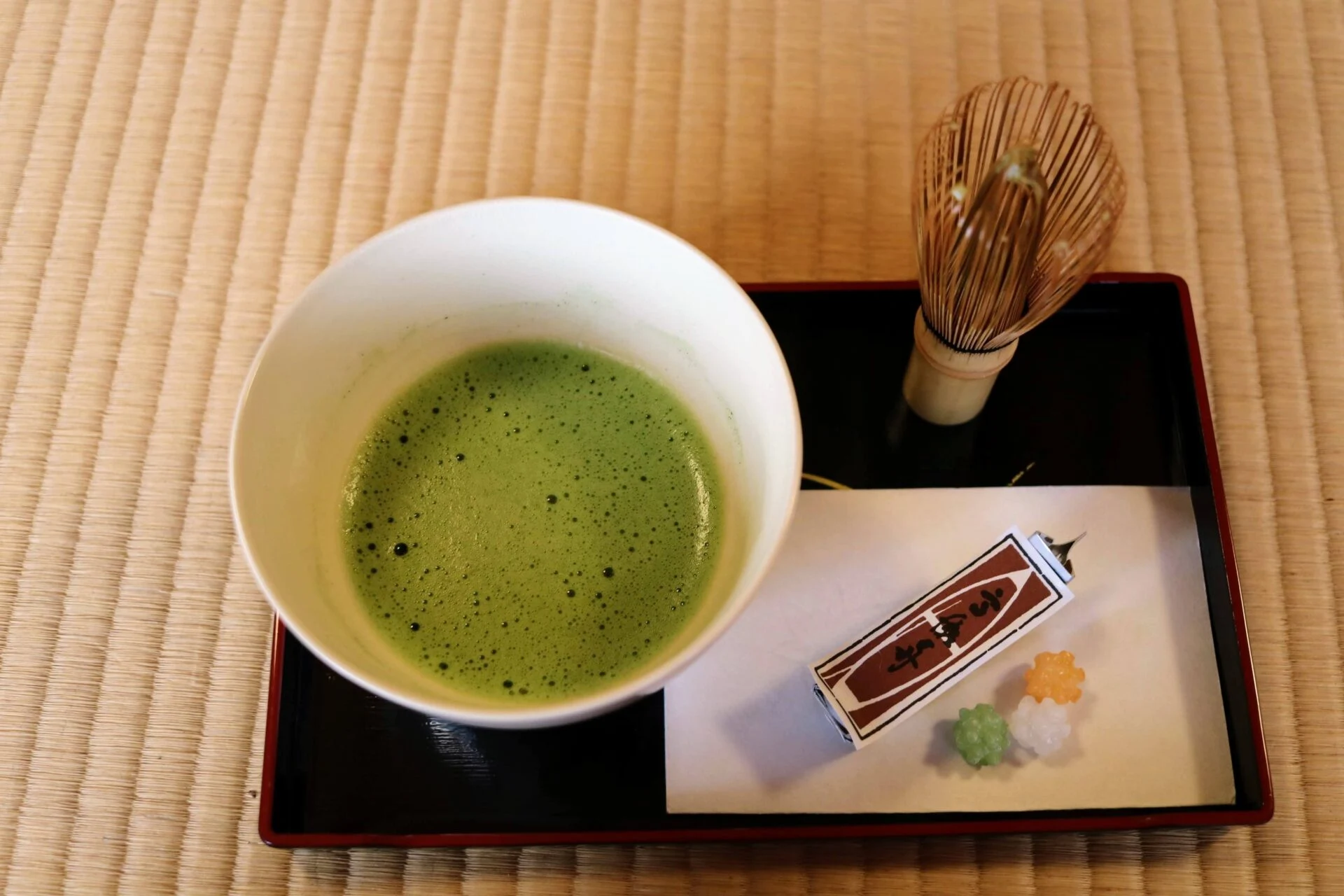 抹茶の入った茶碗とお菓子