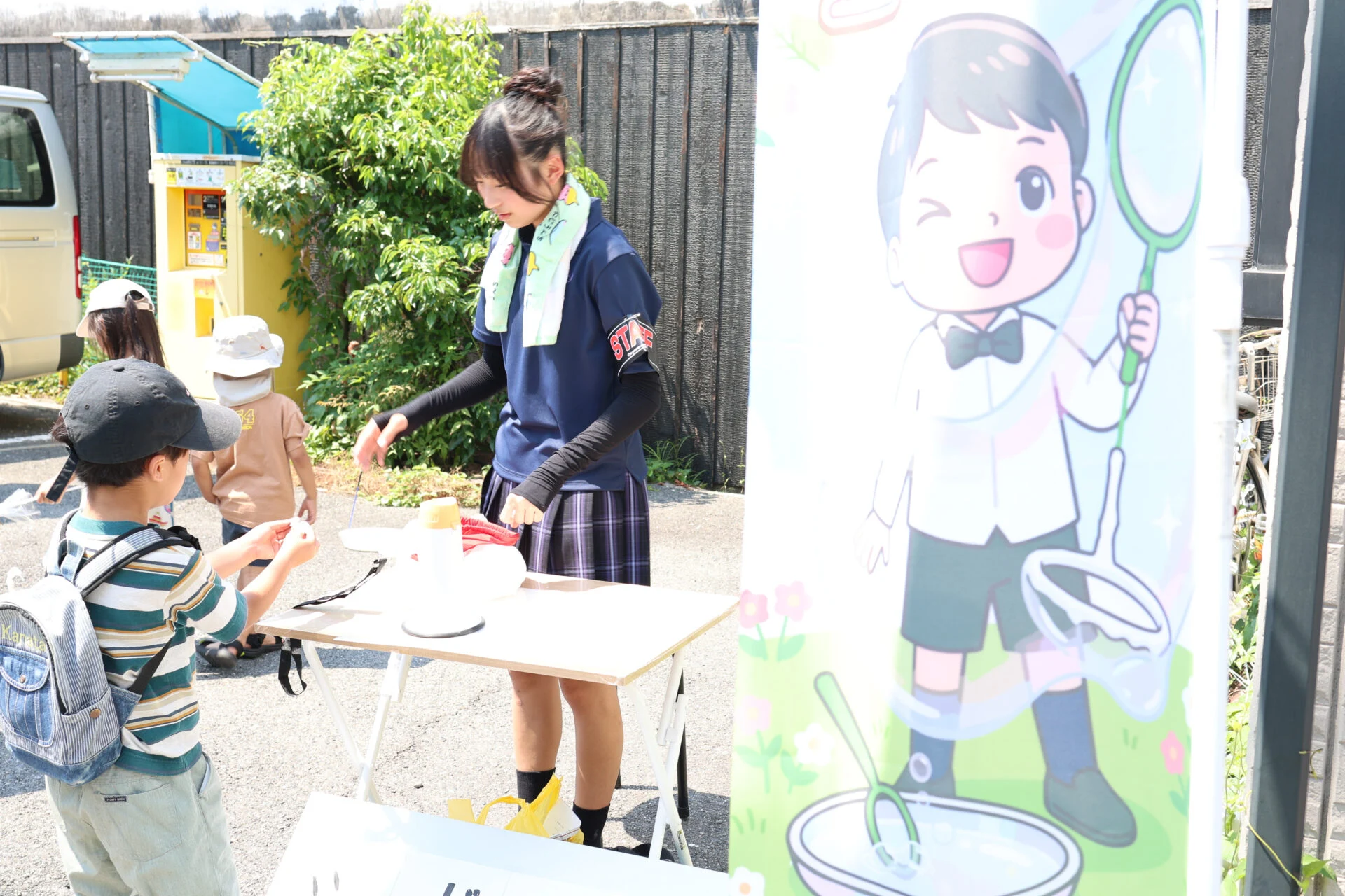 しゃぼん玉コーナーで受付をする高校生