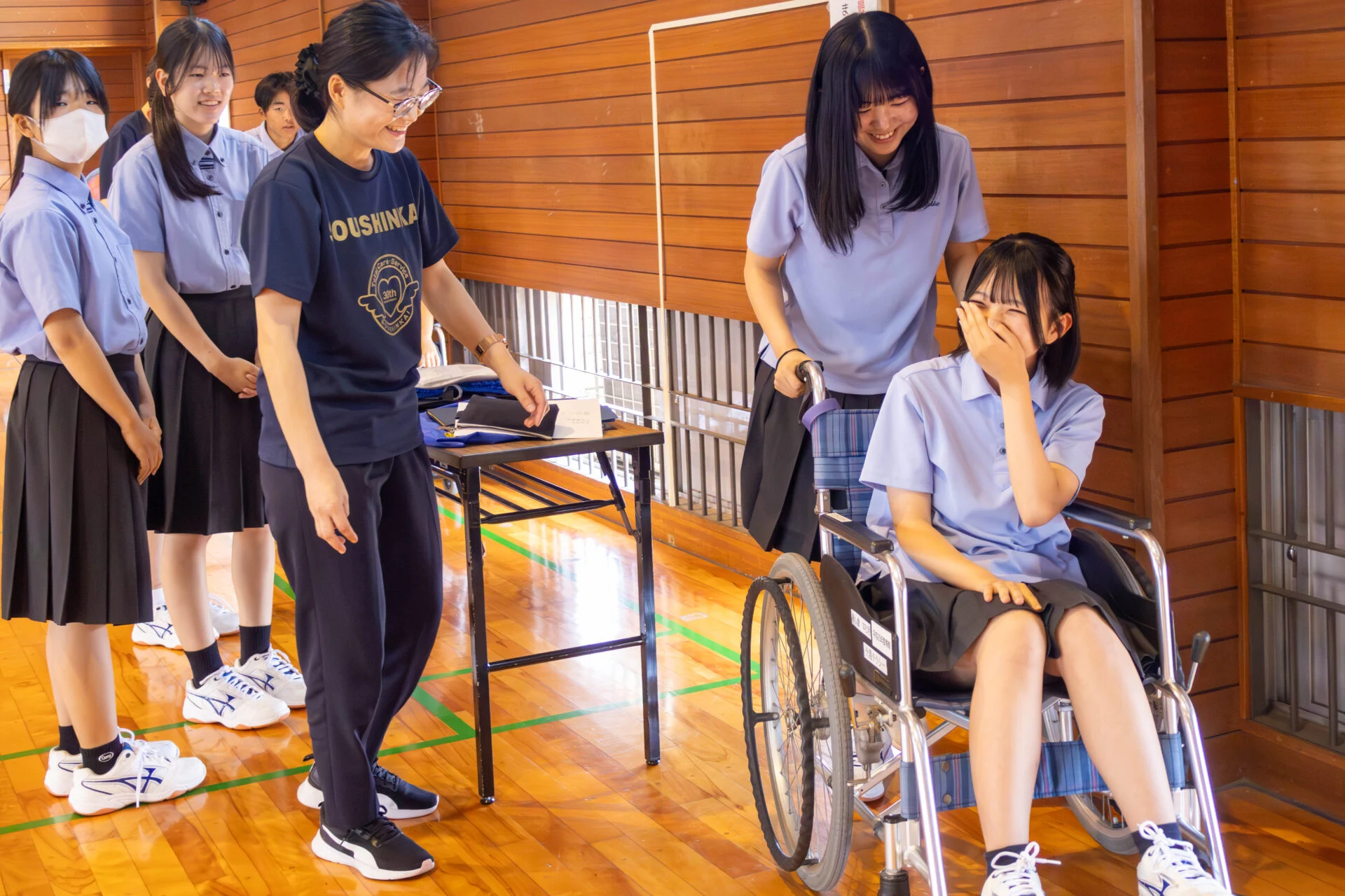 車椅子を体験する生徒2名