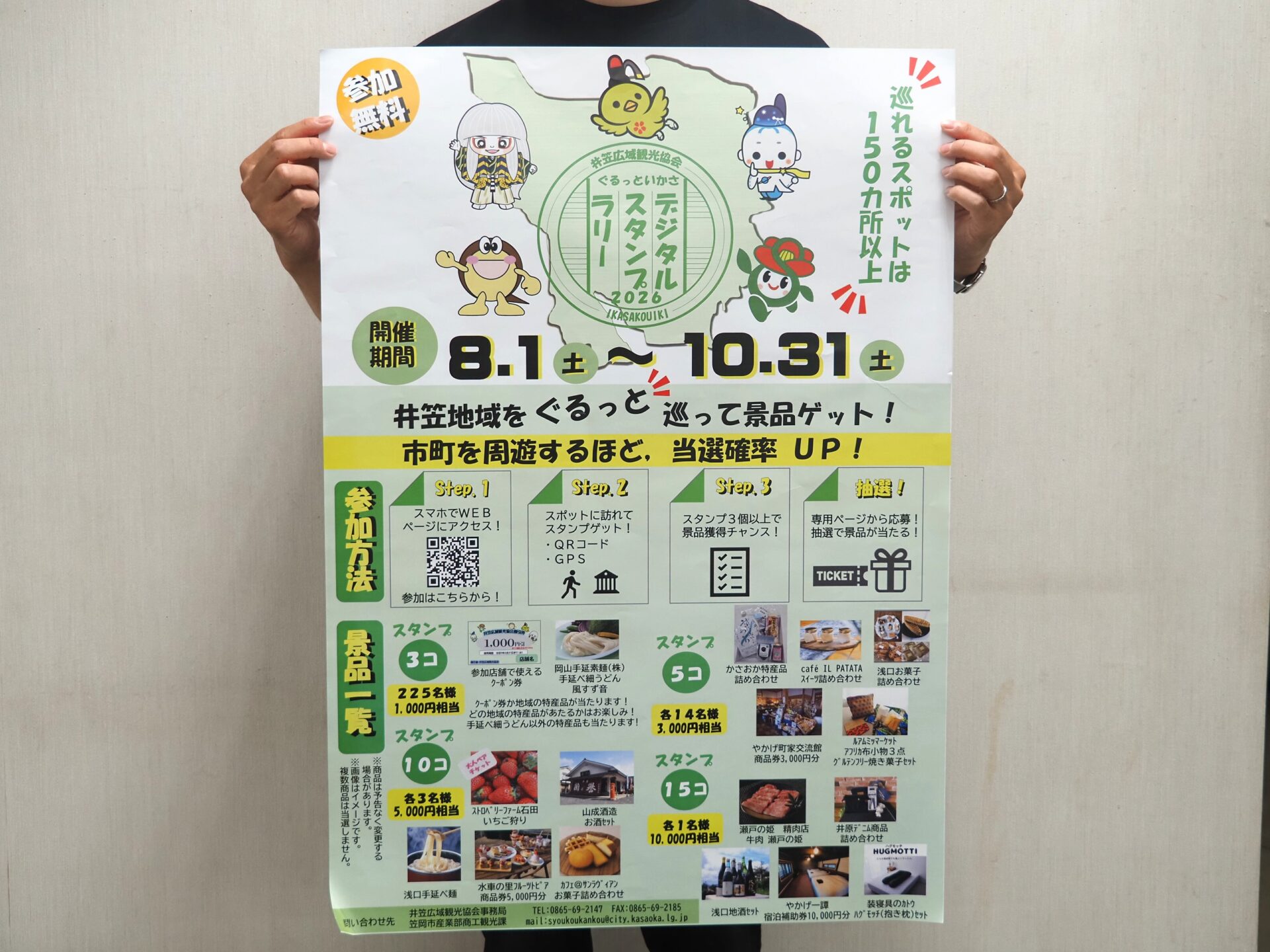 スタンプラリーのチラシを掲げる様子