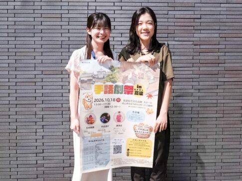 ポスターを持つ事務局担当者